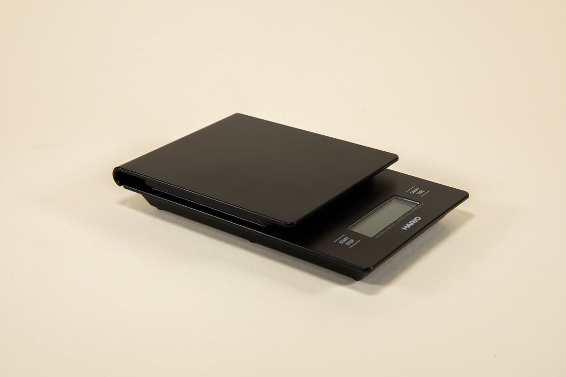 Black plastic rectangular shaped scale with digital screen and set against a light background.