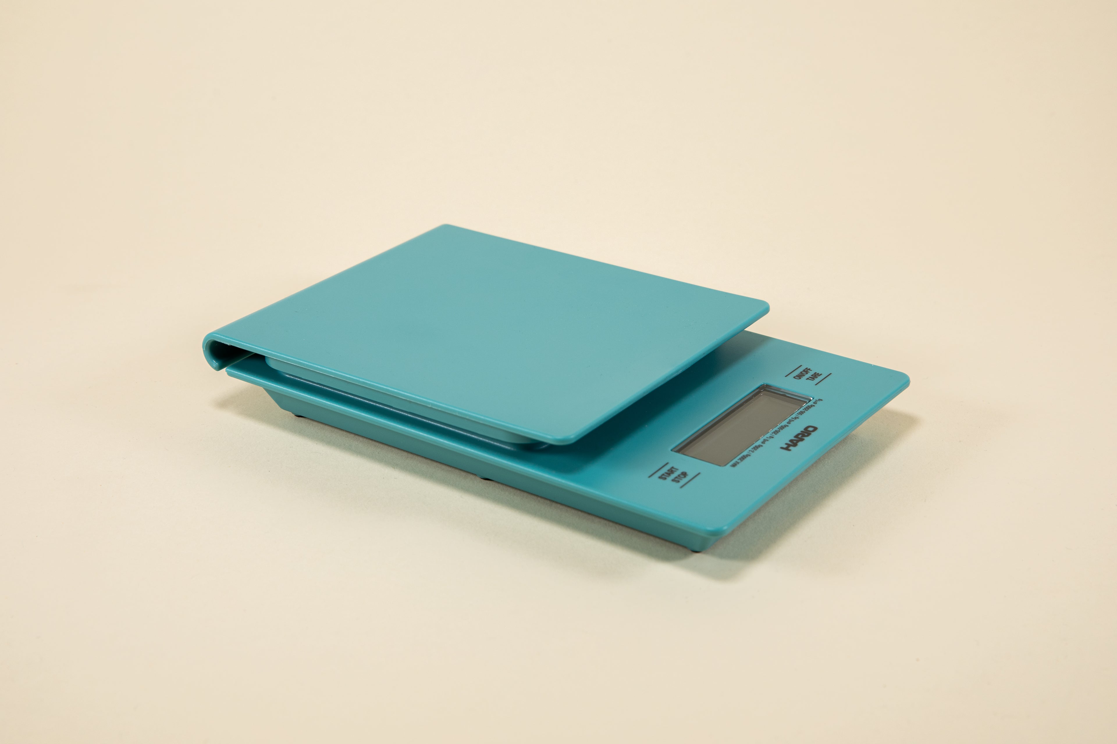 Turquoise plastic rectangular shaped scale with digital screen and set against a light background.