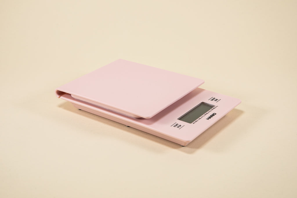 Pink plastic rectangular shaped scale with digital screen and set against a light background.