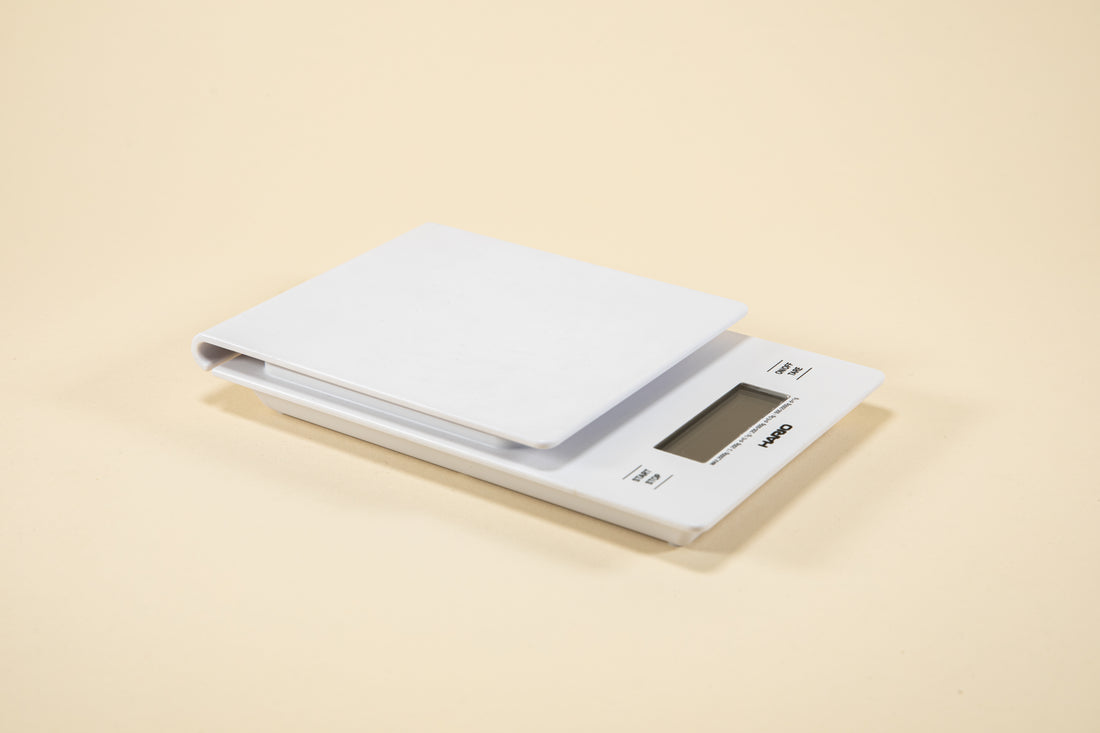 White plastic rectangular shaped scale with digital screen and set against a light background.