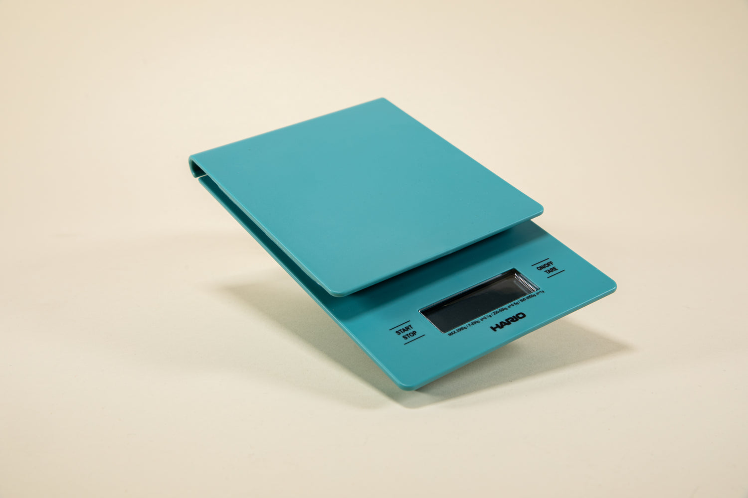 Turquoise plastic rectangular shaped scale with digital screen and set against a light background.