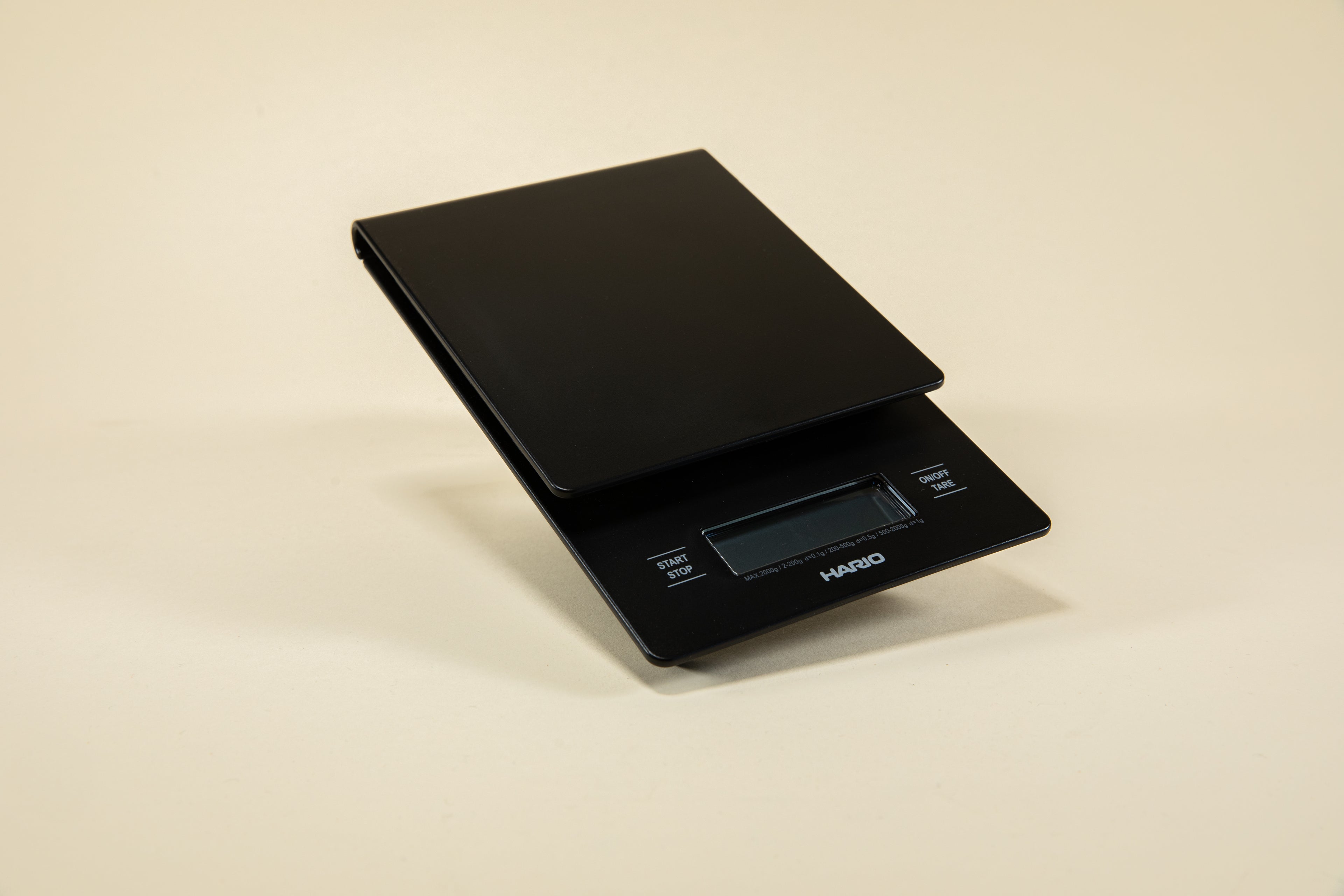 Black plastic rectangular shaped scale with digital screen and set against a light background.