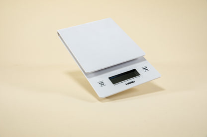 White plastic rectangular shaped scale with digital screen and set against a light background.