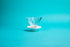 Fluted, flower-shaped glass cone with white plastic base and set against a blue background.