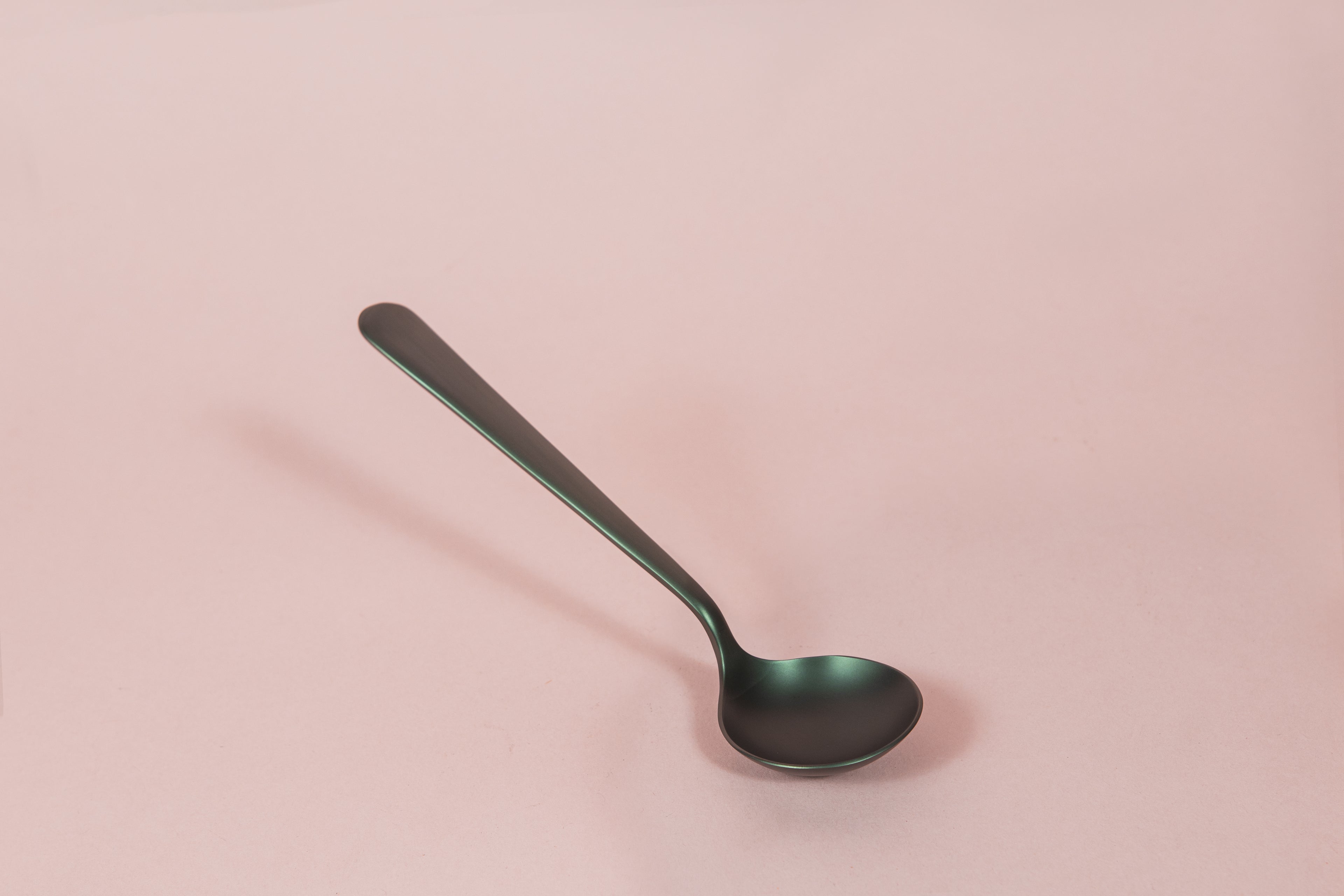 Matte black metal coffee cupping spoon.