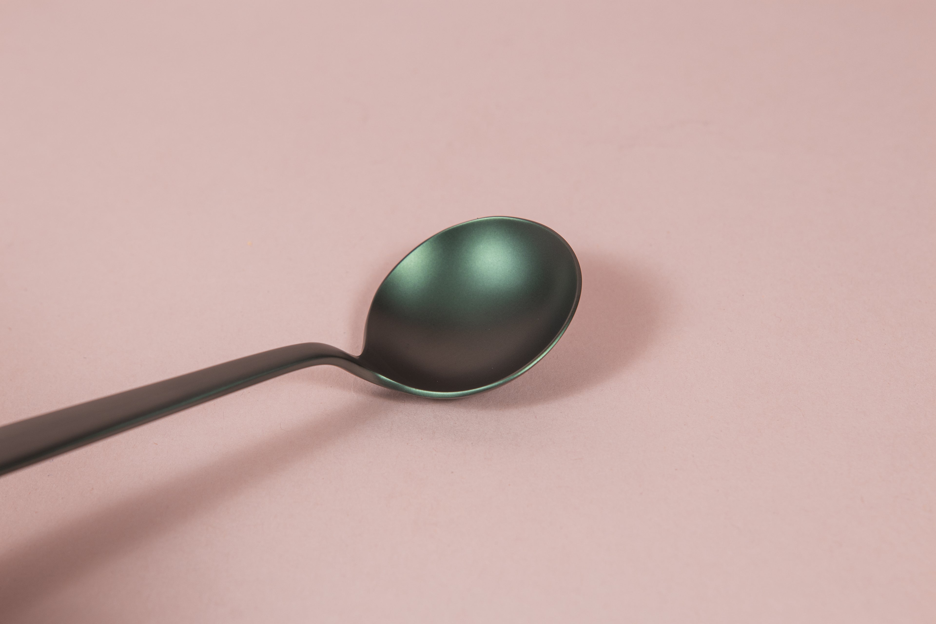 Matte black metal coffee cupping spoon.