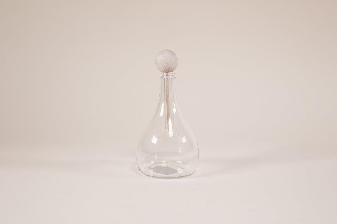 Tear drop shaped glass diffuser with natural wood wand and knob.