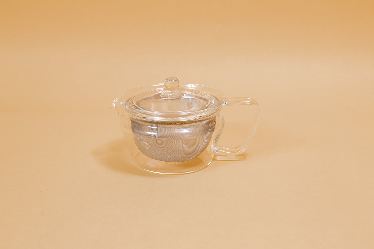 All glass tapered tea pot with flat bottom, all glass lid and handle, and metal mesh filter basket insert.