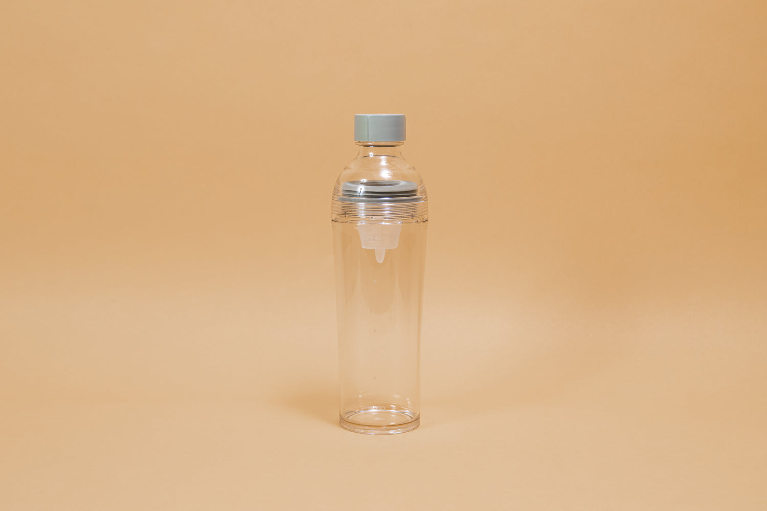 Clear plastic bottle with removable nylon tea strainer and green plastic cap.