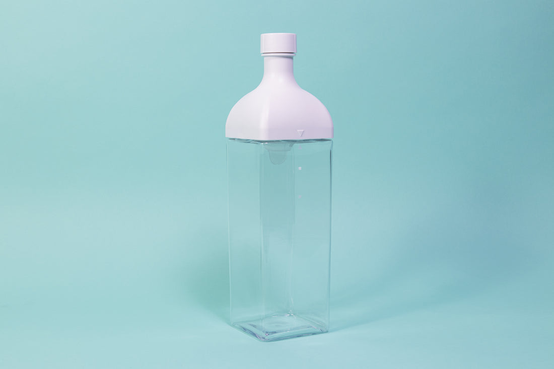 Clear plastic rectangular jug with white rectangular top and round cap.