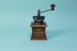 Rectangular wood grinder and drawer with dark metal grinder hopper and handle.