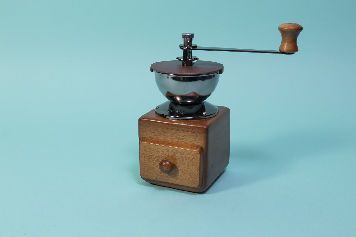 Wooden cube and drawer with dark metal grinder hopper and handle on top