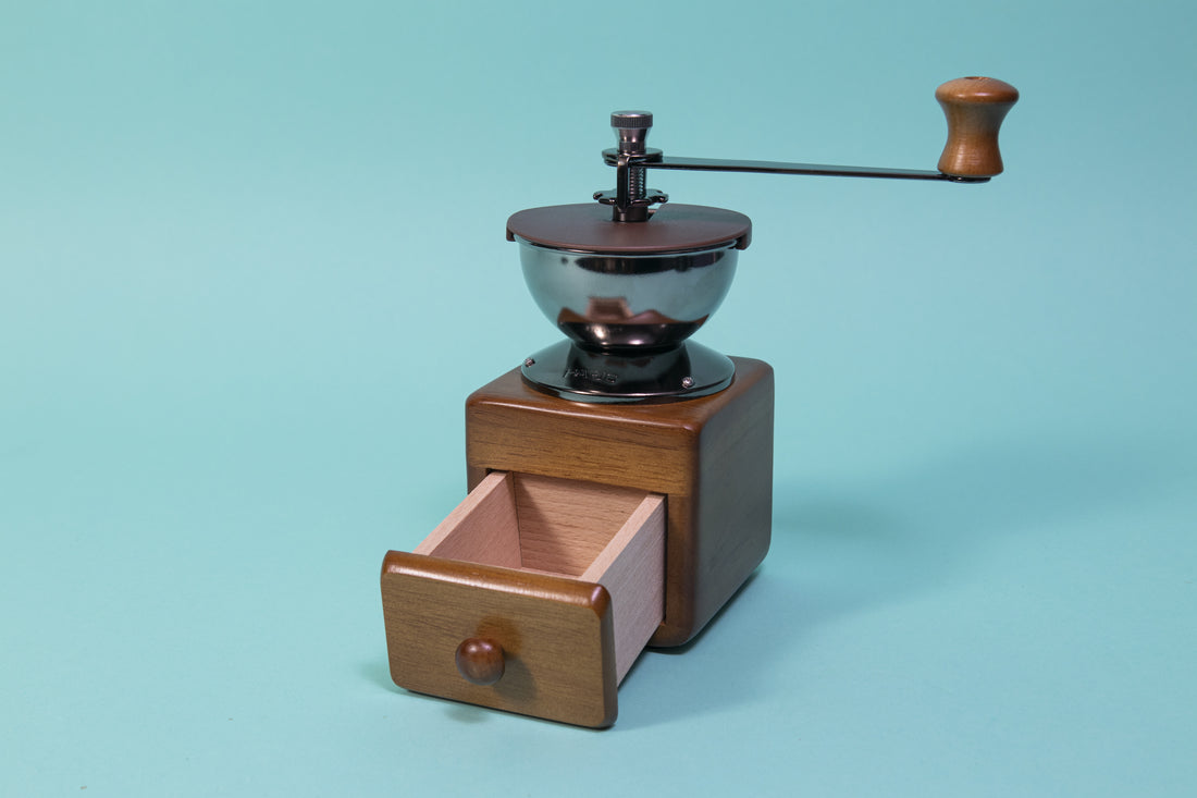 Wooden cube and drawer with dark metal grinder hopper and handle on top