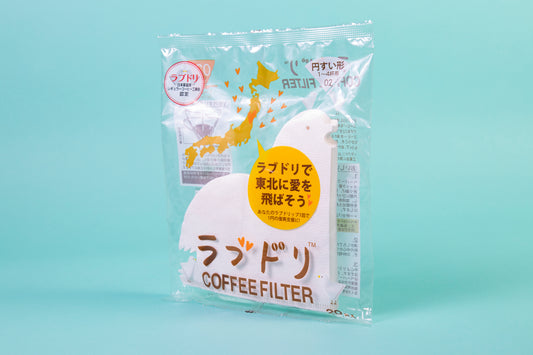 White bird-shaped cone paper filters in a clear plastic bag and set against a blue background.