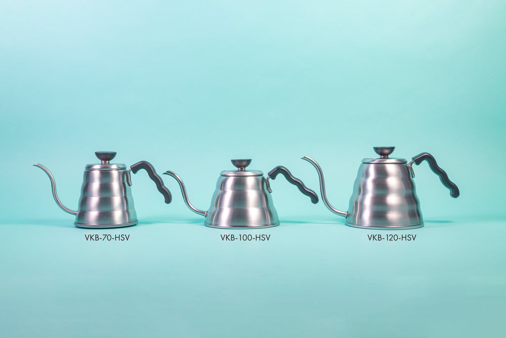 Three silver beehive-shaped stainless steel kettles of varying sizeswith wave-shaped black plastic handles and round black plastic lid knobs with flat tops set against a light blue background.