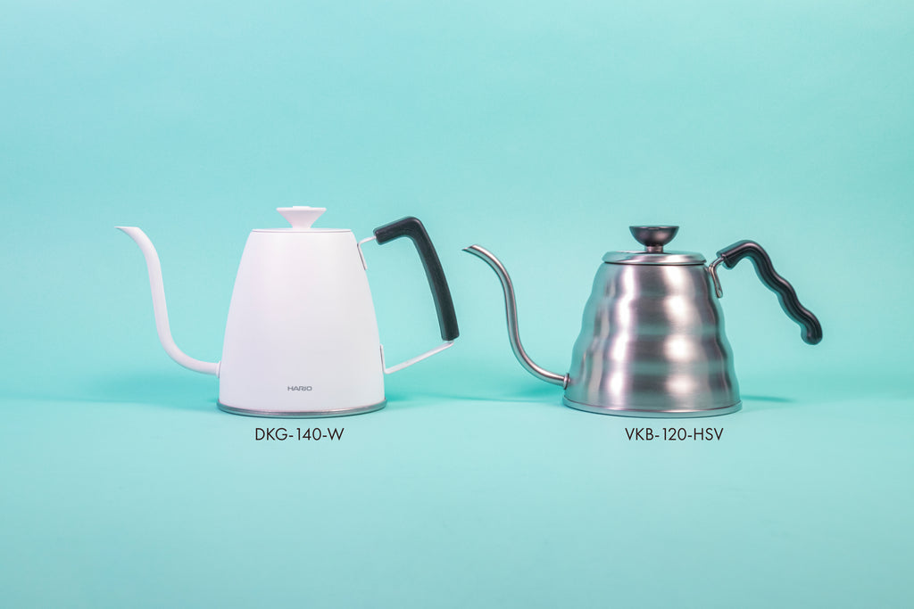Matte white metal gooseneck kettle with white lid knob and black rubber handle cover and silver beehive-shaped body and black plastic handle and knob set against a light blue background.
