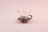Clear glass cone shaped dripper with round black plastic base and handle.