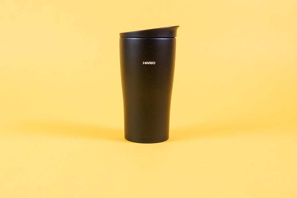 Textured black coffee tumbler with white Hario logo and black lid.