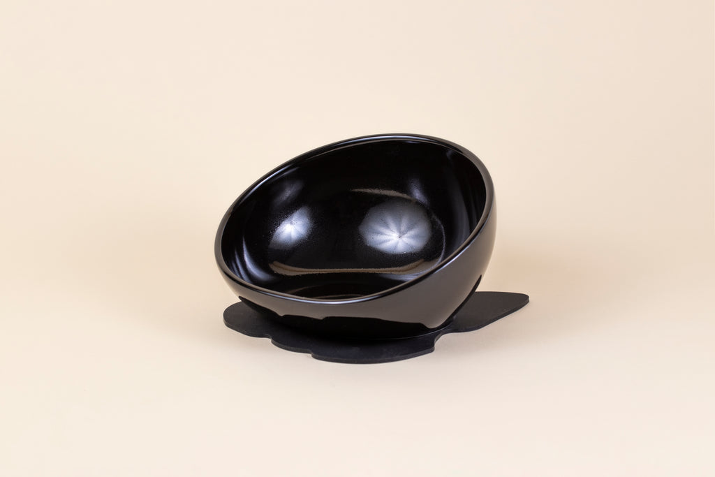 Black porcelain pet bowl sitting on a non-slip, silicone rubber mat in black.