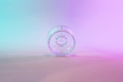Clear plastic ring with interior smaller ring and holes for liquid to drain through. Set on a blue to purple gradient background.