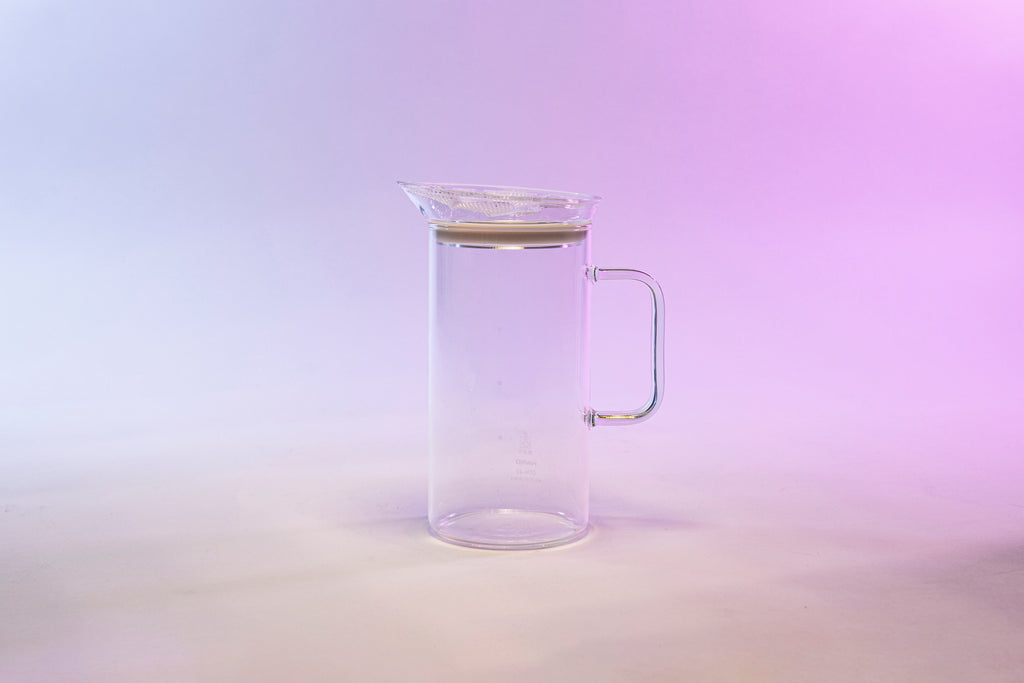 Slim clear glass tea carafe with full glass handle and plastic resin filter mesh on the top the lid.