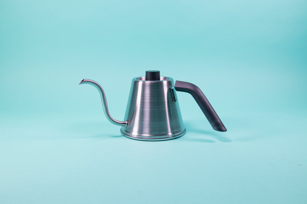 Silver stainless steel kettle with black plastic handle and short cylindrical black plastic lid knob set against a blue background.