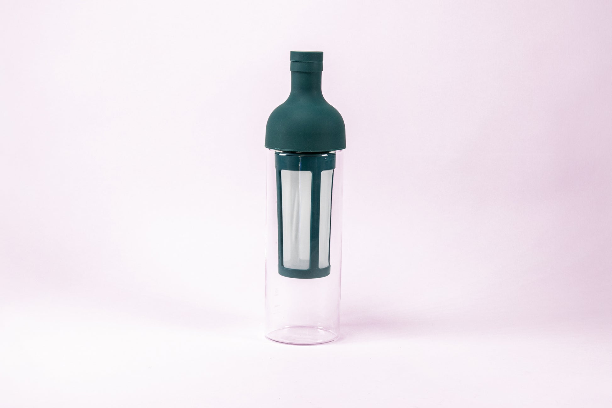Tall glass container and white nylon mesh coffee filter, with teal rubber wine bottle shaped top.