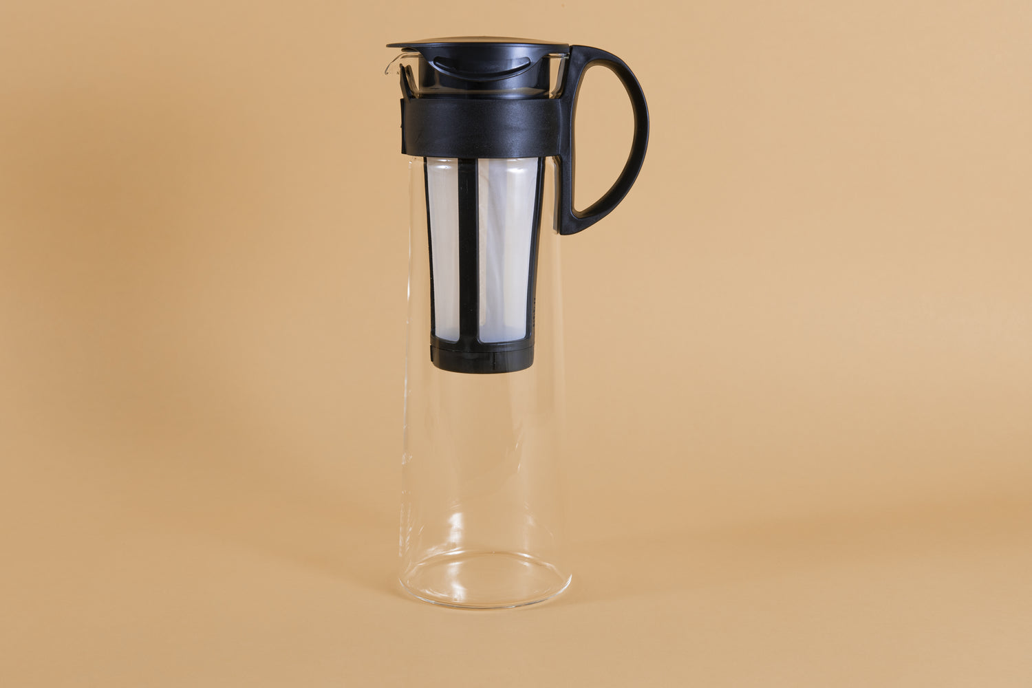 Tall glass server with white nylon mesh coffee filter insert and black plastic handle and lid.