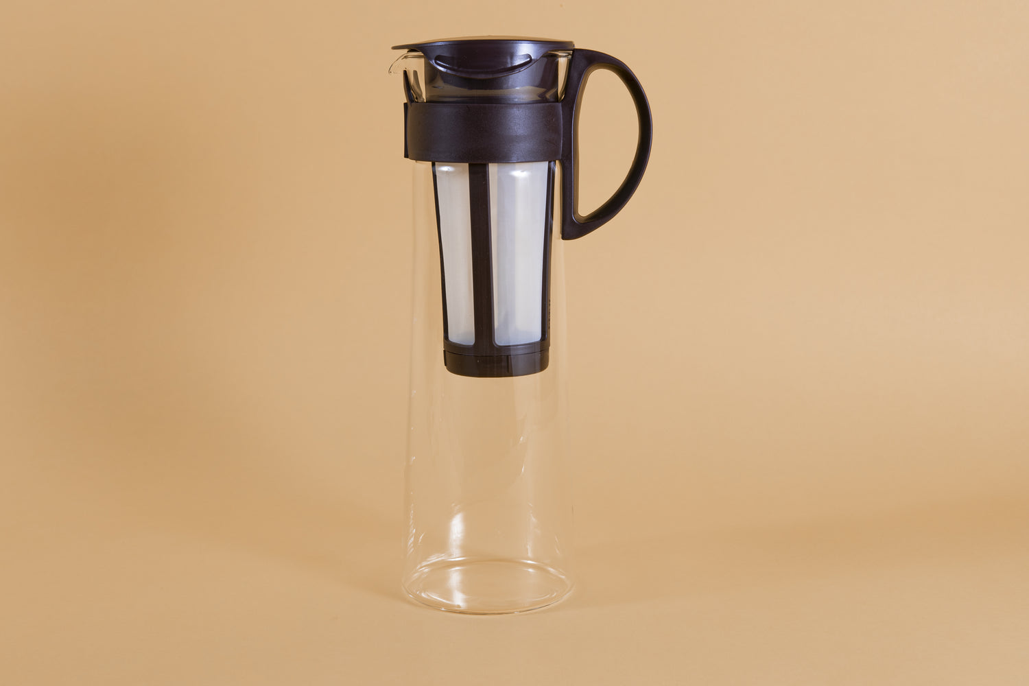 Tall glass server with white nylon mesh coffee filter insert and chocolate brown plastic handle and lid.