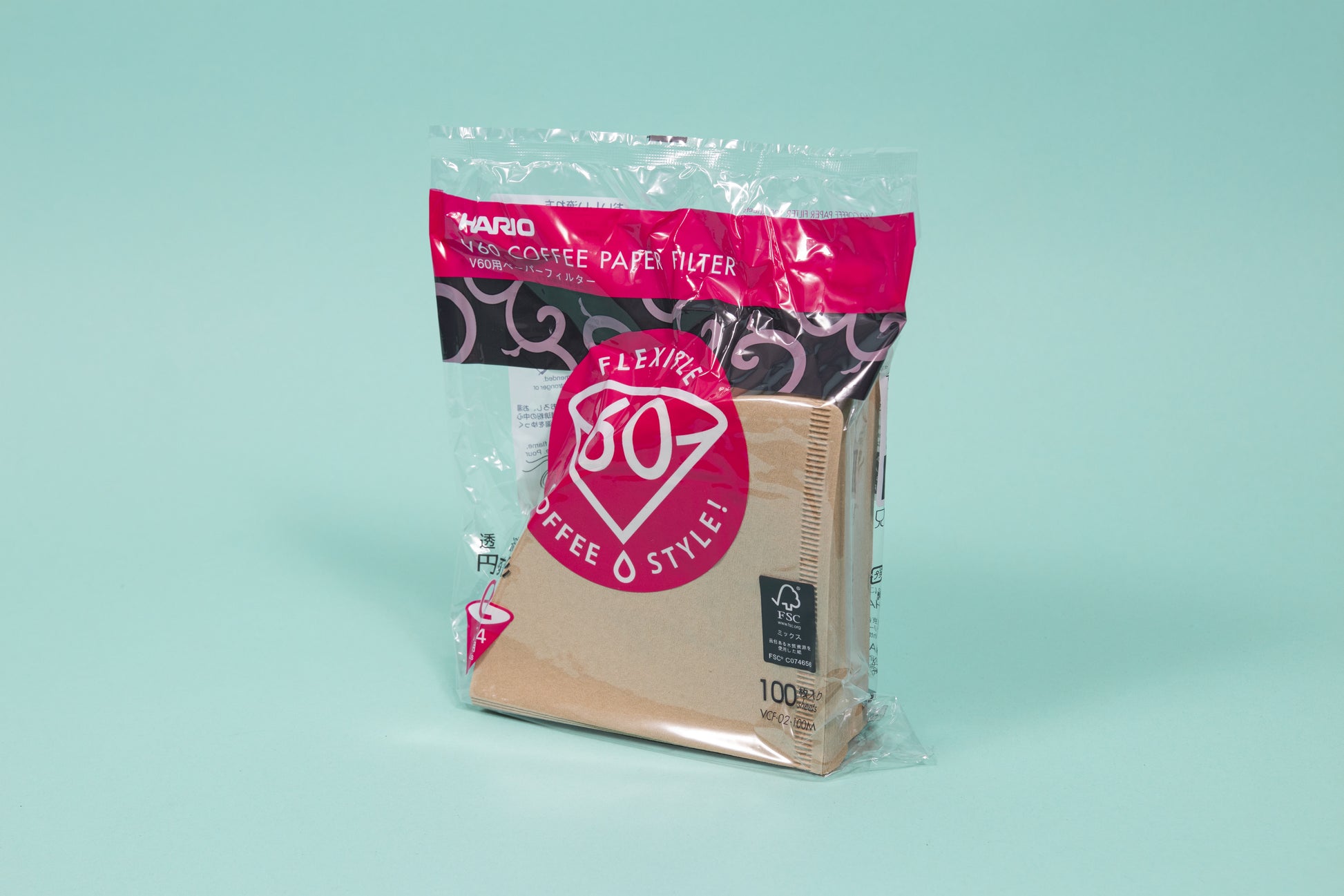 Brown cone shaped paper filters in a plastic bag with pink and black accents and set against a blue background.
