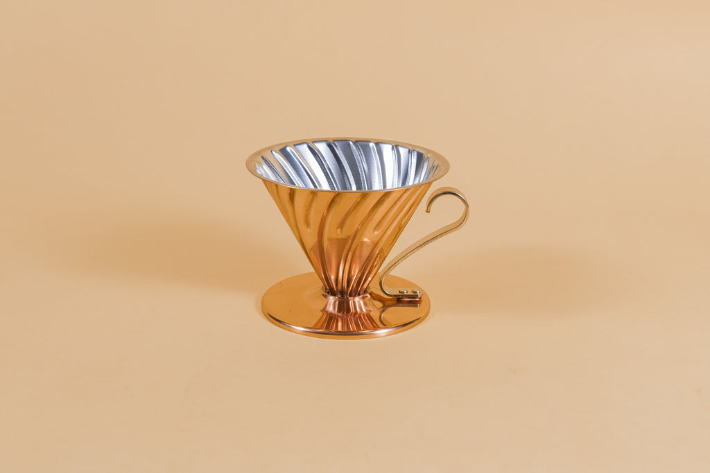 Copper plated cone shaped coffee striper with ornate handle and round base 