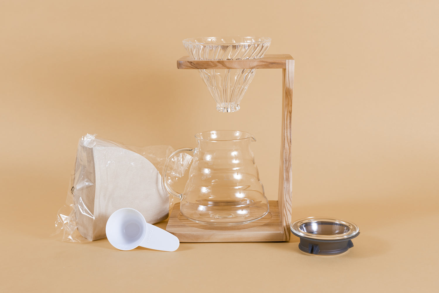 Wooden stand with clear glass conical dripper and all glass glass server, With a plastic pack of filters and scoop and glass lid.